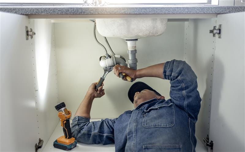 Plumber repairing kitchen sink drain pipes in Wildwood, Georgia